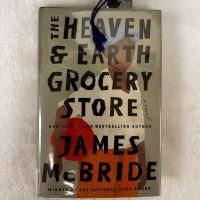 Book cover for The Heaven & Earth Grocery Store by James McBride. Cover depicts a painting of a man holding a basketball.