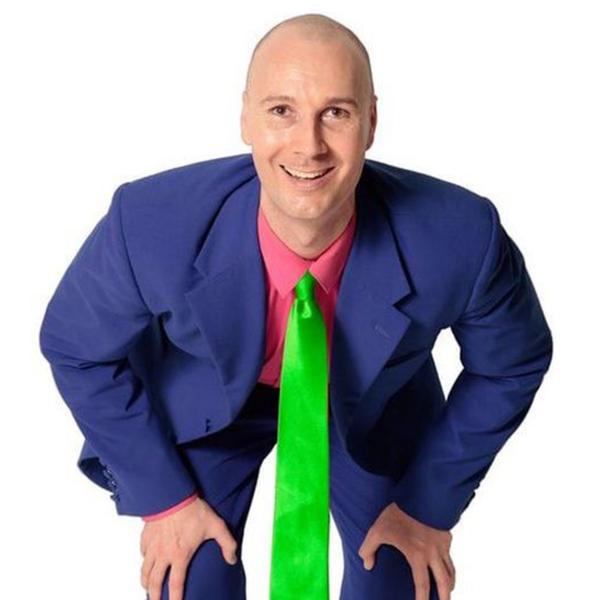 Christopher T. the magician wearing  navy blue suit and neon green tie 