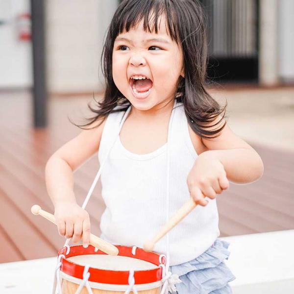 Toddler playing with a drum