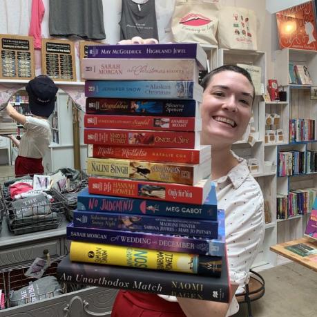 Leah Koch holding a tall stack of books