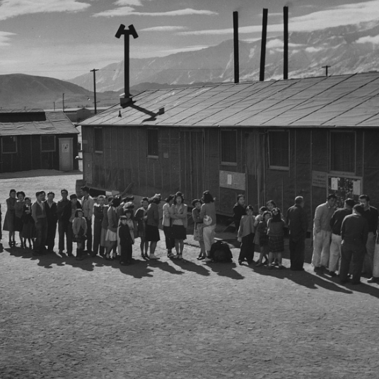 Historical photo of Japanese Americans entering Manzanar Relocation Center