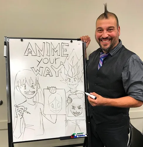 man standing pointing at a whiteboard displaying anime sketch