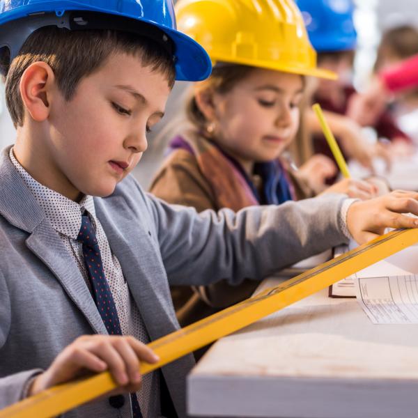 Children designing blueprint for house