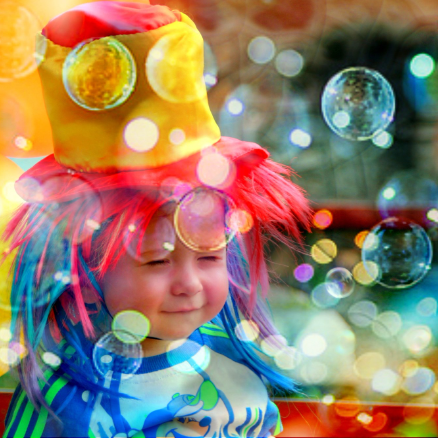 Child in clown hat and bubbles