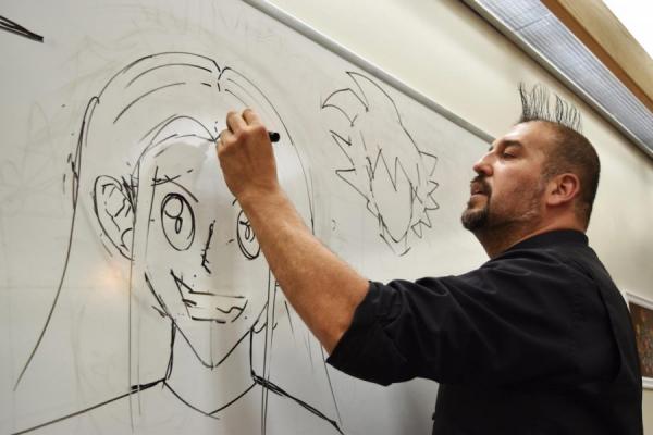 Man drawing anime character on a whiteboard 