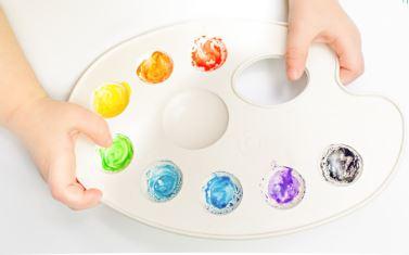 Child Hands Holding Paint Palette 