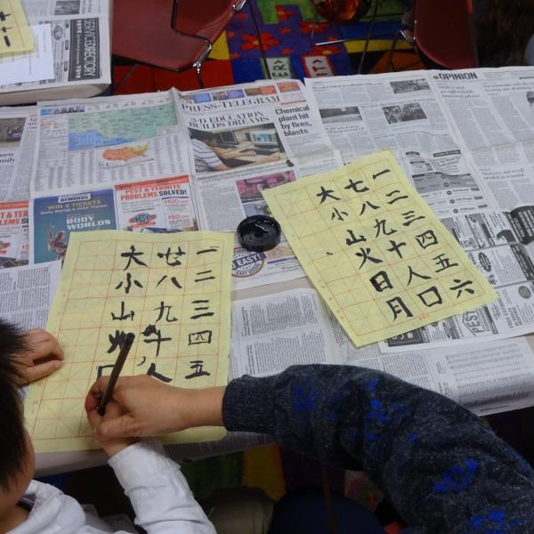 someone writing Chinese Calligraphy