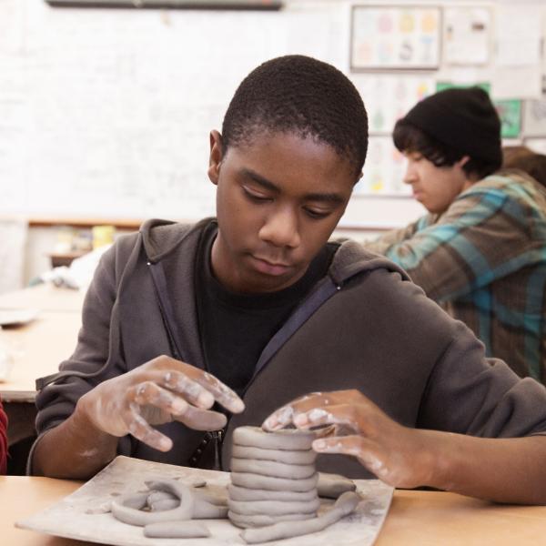 teen making coiled vase with modeling clay
