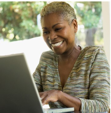 Lady smiling typing on laptop 