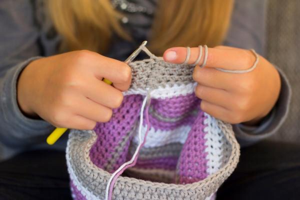 Hands knitting a cap.