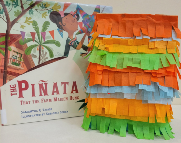 Handmade pinata next to book titled The Pinata