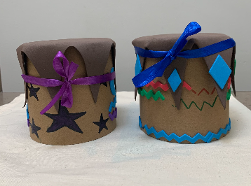 Decorated cardboard drums with stars and ribbons and other colorful designs.