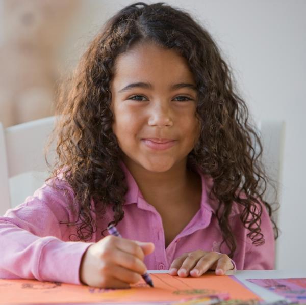 Young girl coloring with crayons