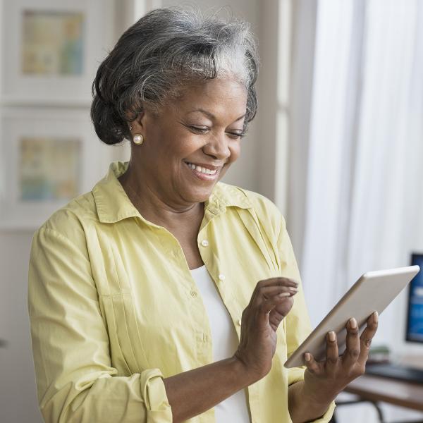 Older lady smiling using tablet