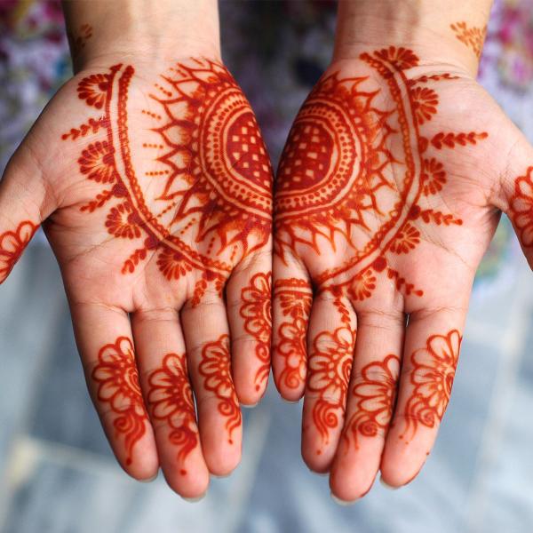 Two hands with henna design on palms 