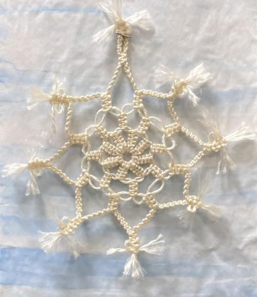 Snowflake design crafted from knots of white cotton macrame cord