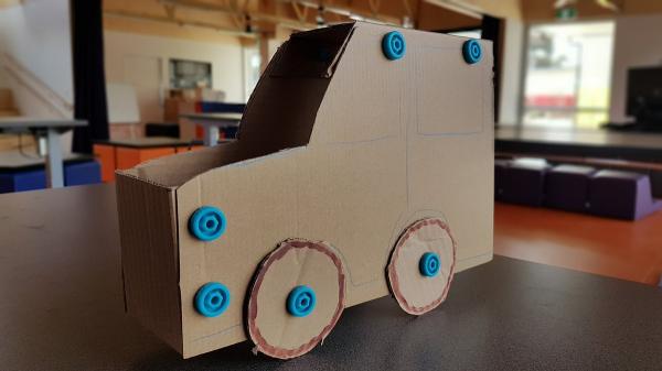 Cardboard toy car held together with blue plastic screws.