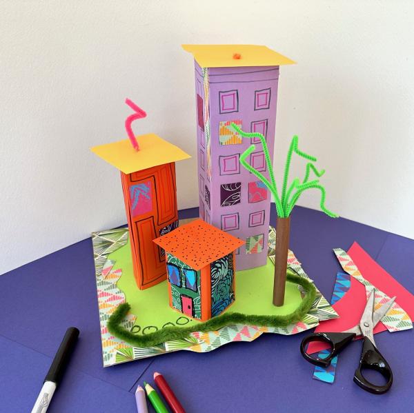 Town constructed from art materials like cardboard, colored paper, and pencils 