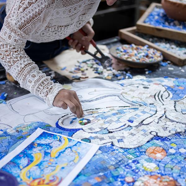 Female artist working on mosaic project in workshop