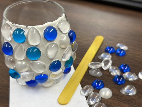 Mosaic votive holder with blue and white gems.