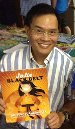 Oliver Chin holding Julie Black Belt book