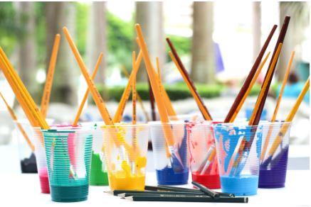image of various cups filled with paint with paint brushes. 