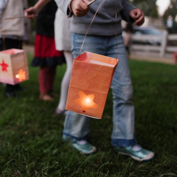 Kid holding paper bag lantern with star shaped cutout