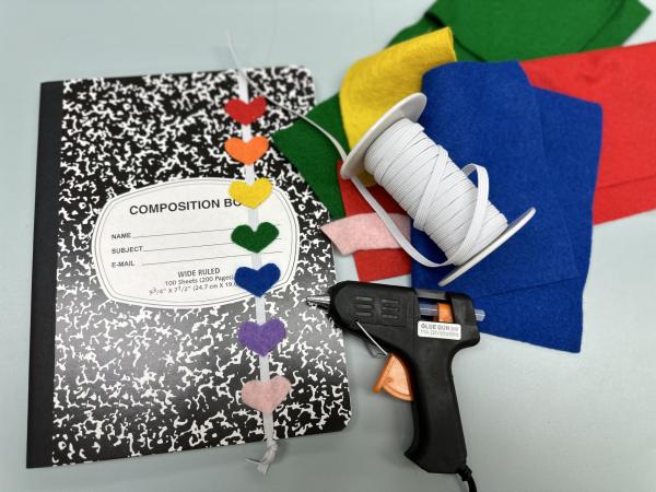 Composition notebook closed with a rainbow book band.