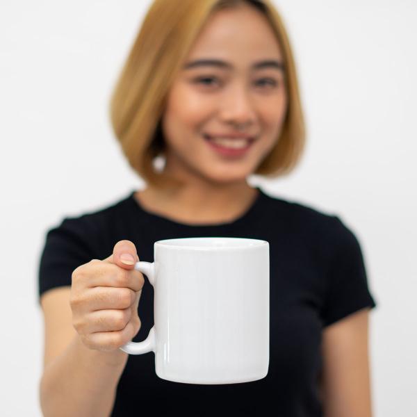 Girl in black t-shirt holding white mug.