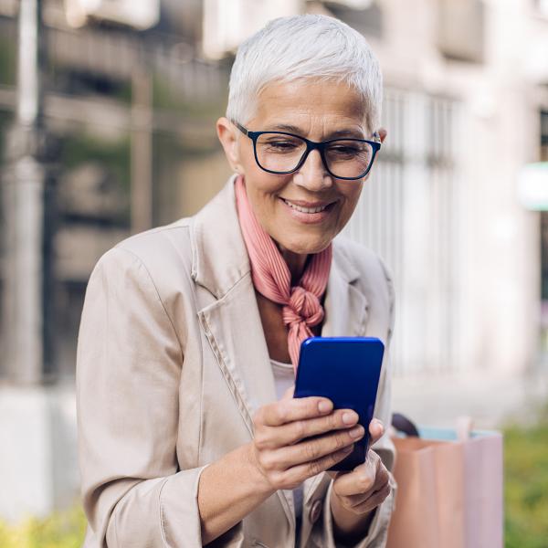 Older lady looking at cell phone, smiling
