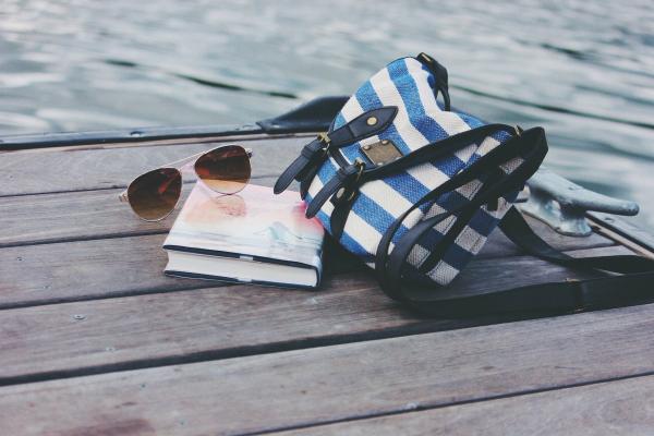 Book and sunglasses next to a cloth bag