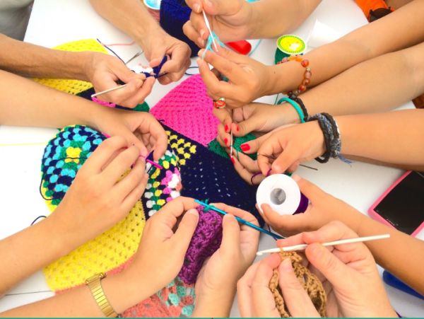 hands crocheting in a circle