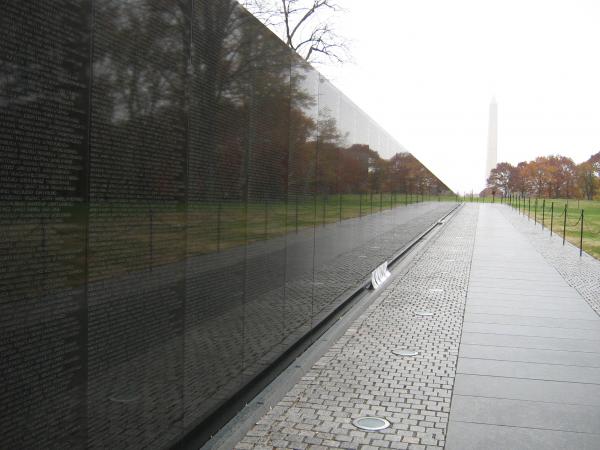 A picture of the Vietnam Memorial Wall with the Washington Monument in the background 