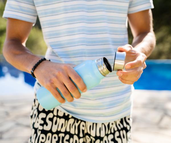 Teen in summer gear holding a water bottle