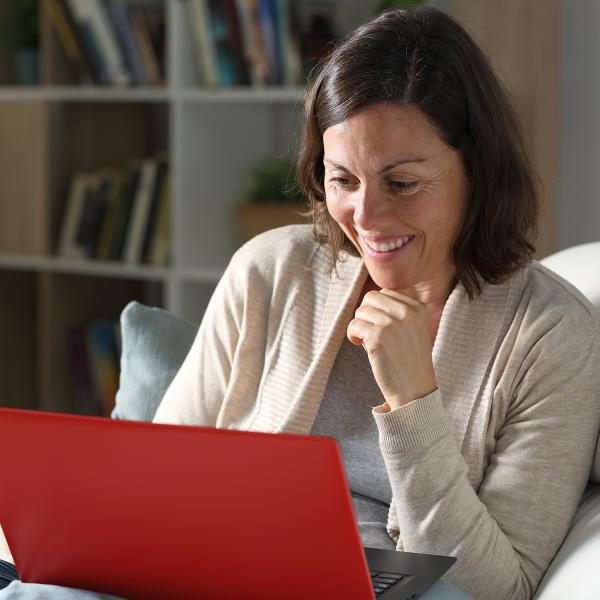 Woman smiling at red laptop.