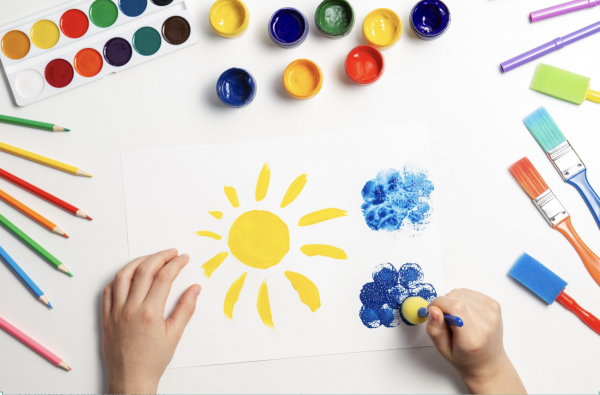 Child's hands painting sun and flowers