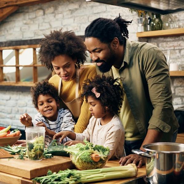 young African-American family cooking in kitchen