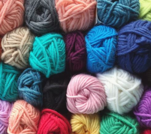 A close up picture of yarn skeins in a multitude of colors. 
