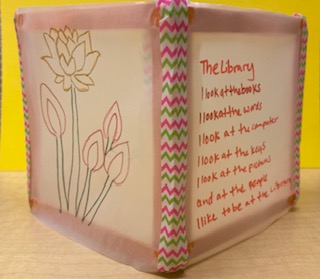 Photo of a paper lantern with flowers drawn on one side and a poem on the other.