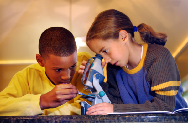 Two children looking through a microscope