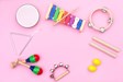 Musical instruments laid out on a pink background.