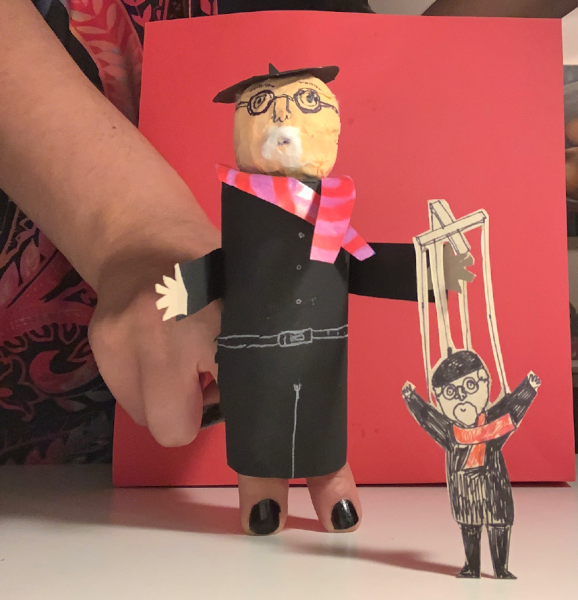 A hand puppet holding a smaller puppet
