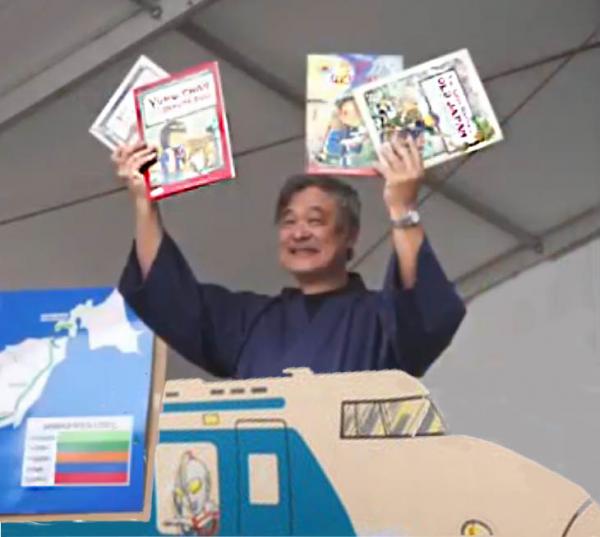 Sunny Seki holding his books above a cardboard train
