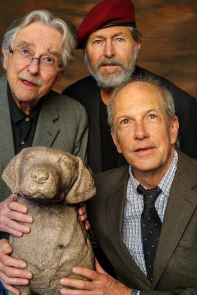 Three men looking into the distance while gathered around a statue of a dog.